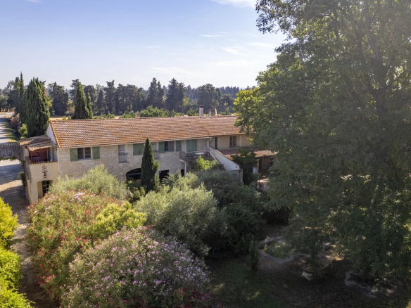 Aerial view of a property with several buildings and a landscaped park in Fourques.
