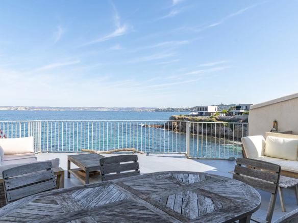 Terrasse avec vue sur la mer Méditerranée et mobilier extérieur.