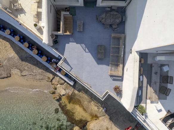 Vue aérienne d'une villa en bord de mer avec accès à une crique privée à Marseille.