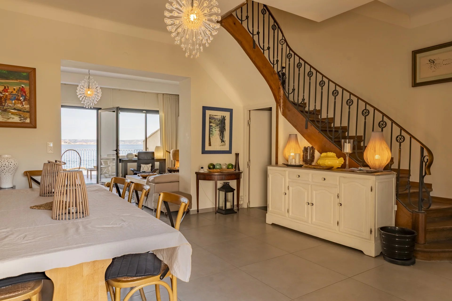 Intérieur de la villa à Marseille Intérieur d'une villa à Marseille avec vue sur la mer, salle à manger et escalier en bois.