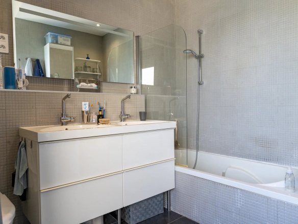 Salle de bain moderne avec baignoire et double vasque.