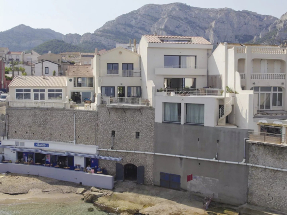 Villa en bord de mer avec accès à une crique privée à Marseille, entourée de montagnes.