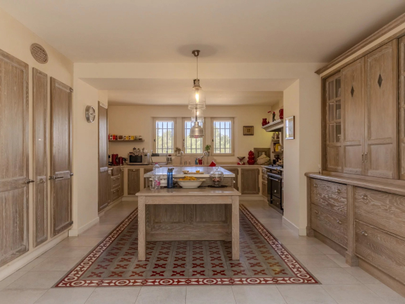 Cuisine spacieuse et lumineuse avec îlot central et rangements en bois.