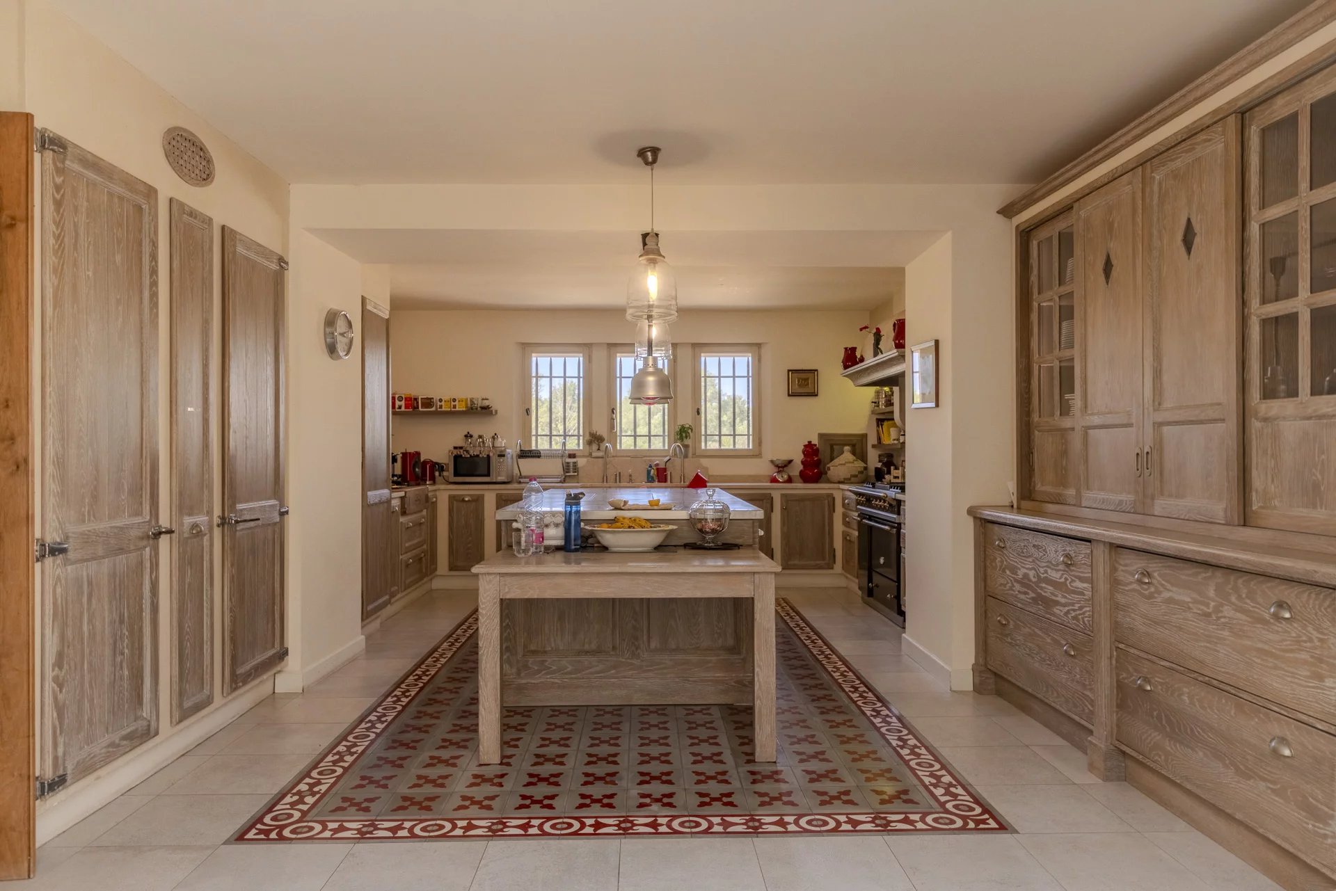 Cuisine spacieuse et lumineuse avec îlot central et rangements en bois.