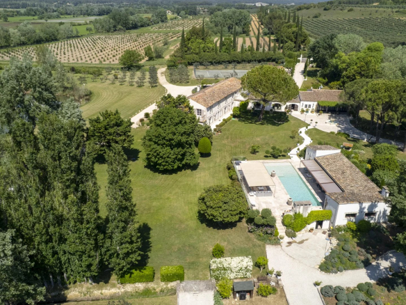 Vue aérienne d'une propriété dans le parc régional des Alpilles, avec jardins et piscine.