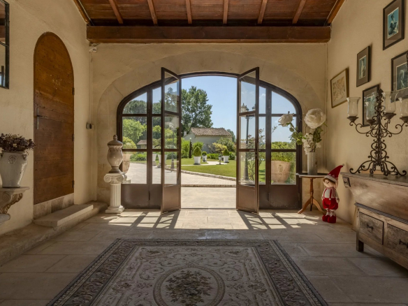 Intérieur d'une propriété avec des portes vitrées ouvrant sur un jardin paysager.