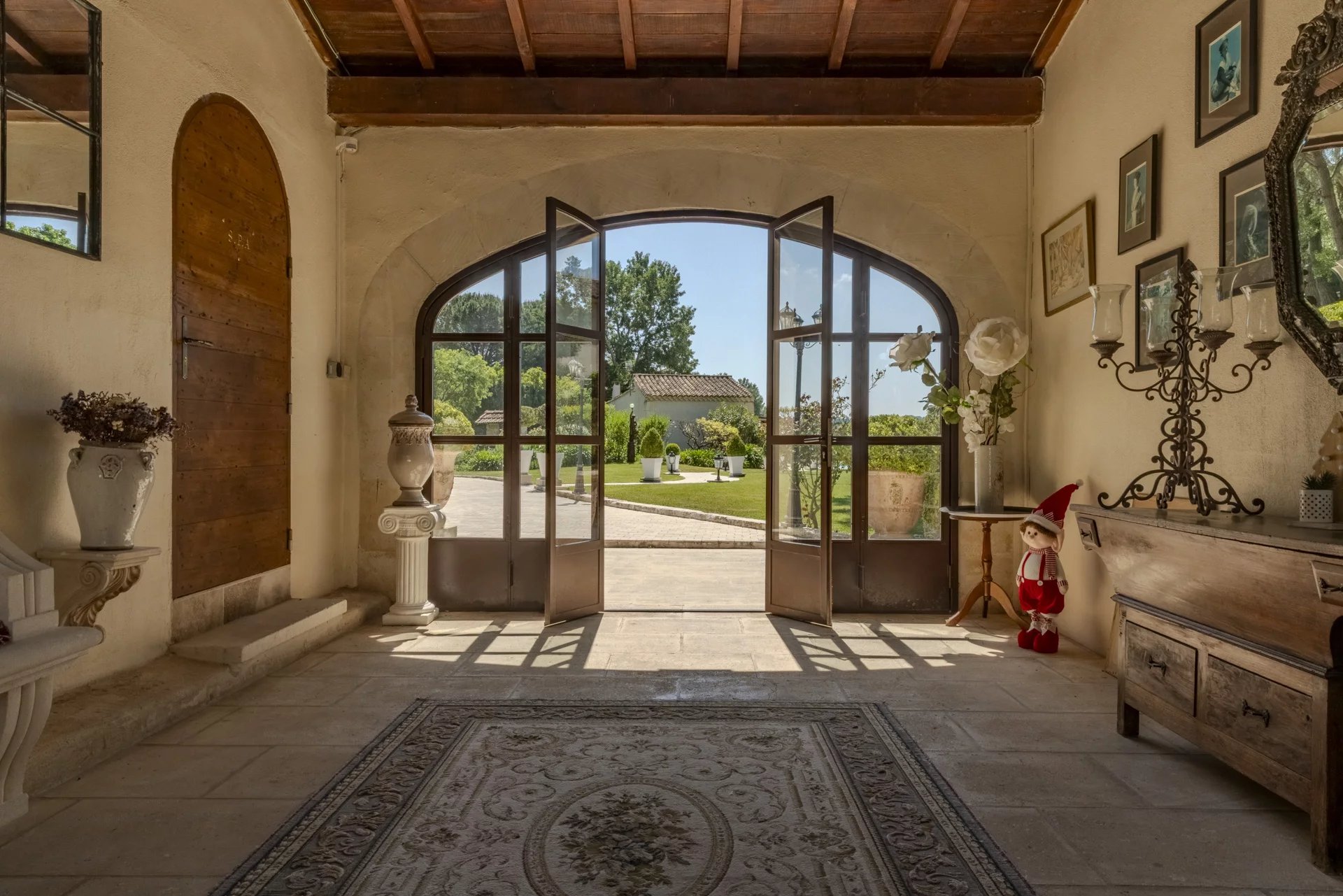 Intérieur d'une propriété avec des portes vitrées ouvrant sur un jardin paysager.