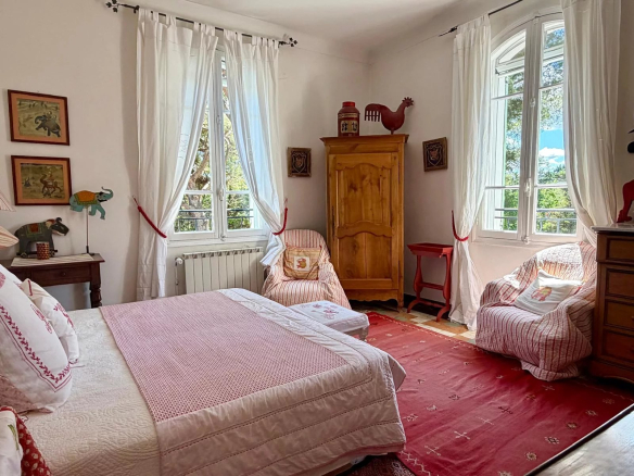 Bright room with bed, armchairs and Provençal decor in a property near Eygalières.