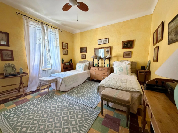 Room with two single beds and vintage decor in a property in Provence.