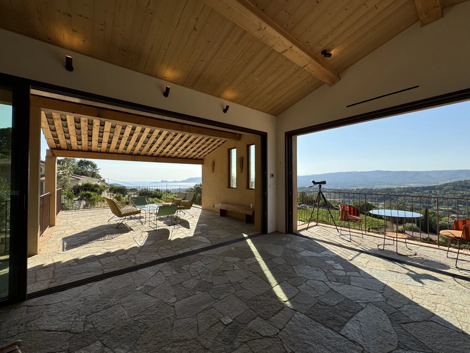 Villa contemporaine à La Cadière-d’Azur Intérieur d'une villa contemporaine avec vue sur la nature, grandes baies vitrées ouvertes.