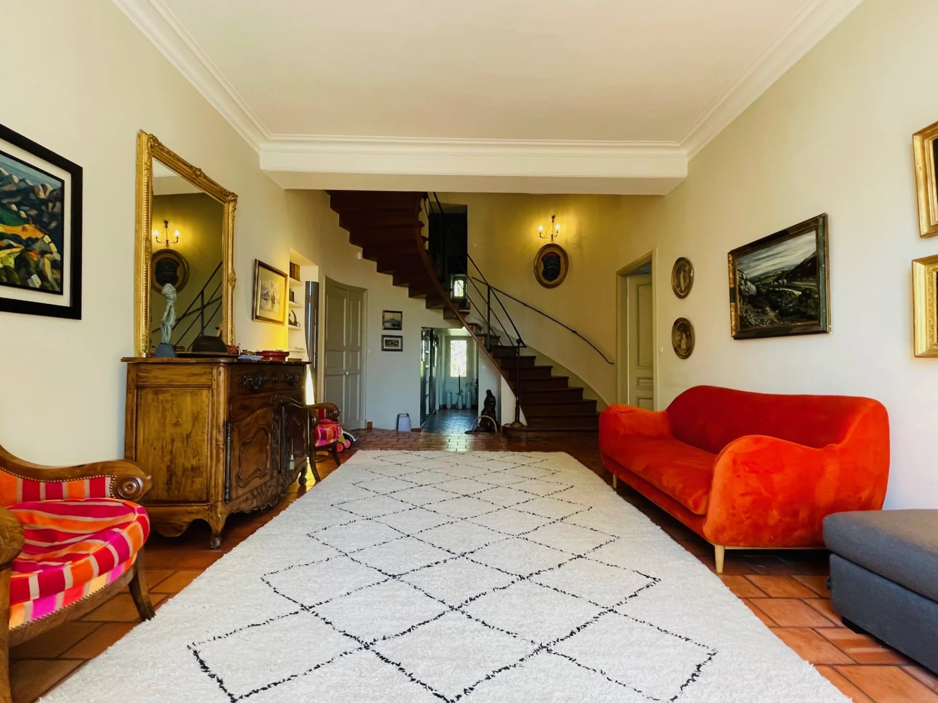 Interior of a Provençal country house Interior of a Provençal country house with a large living room, a wooden staircase and antique furniture.