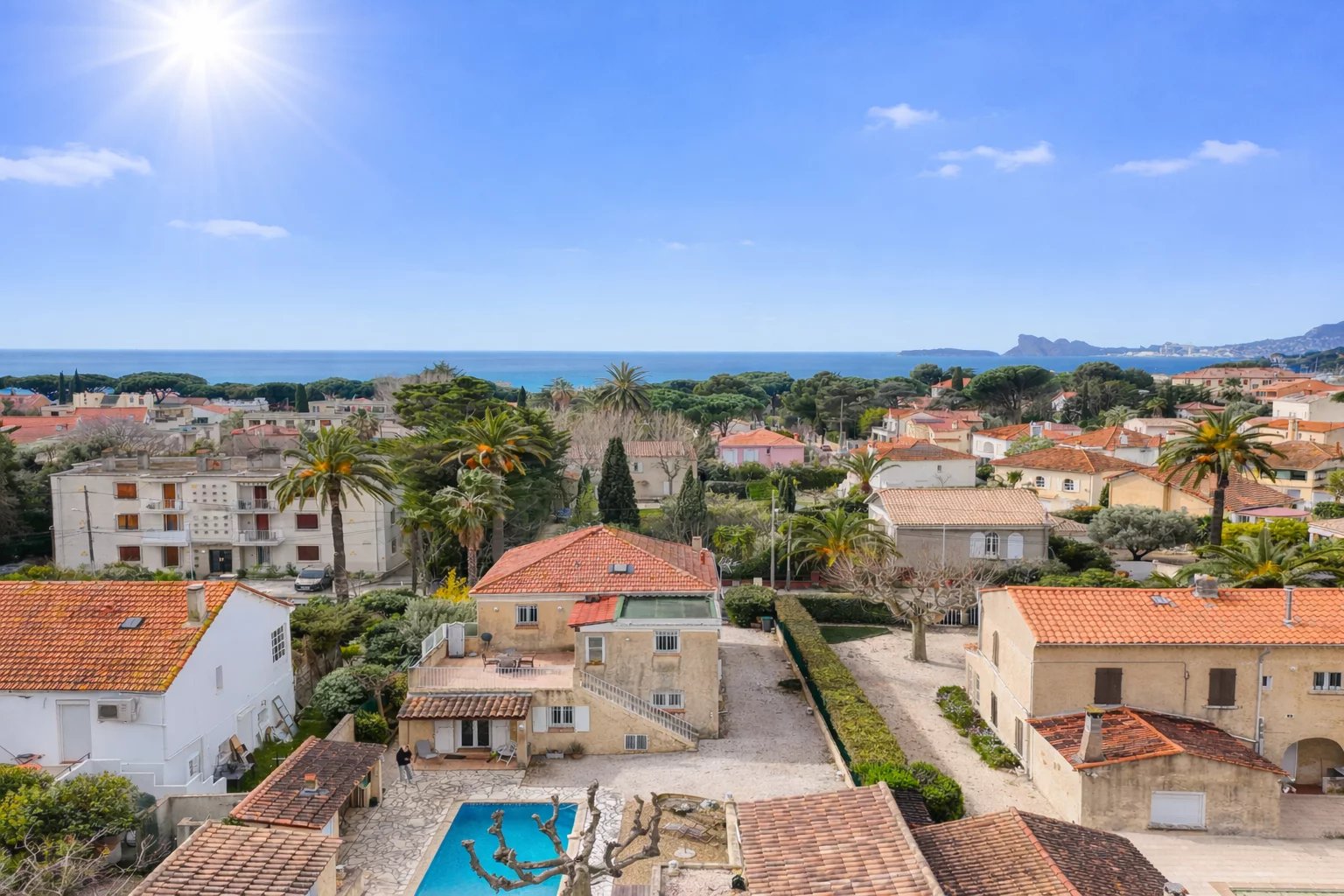 Vue panoramique sur des villas et la mer à Saint-Cyr-sur-Mer, avec piscine au premier plan.