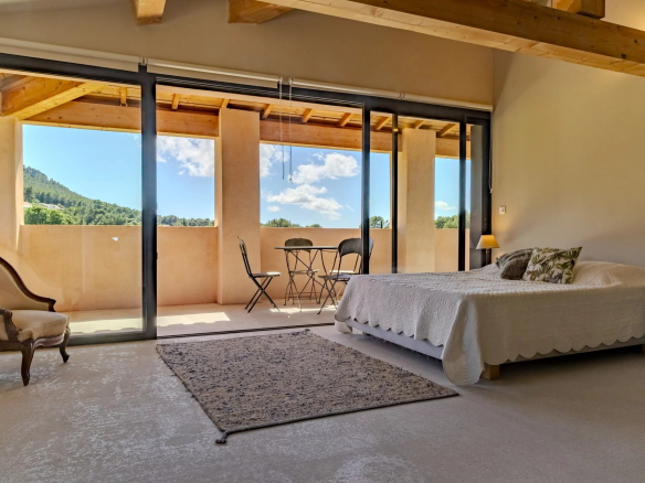 Chambre d'une villa contemporaine avec balcon et vue sur la nature à Roquefort-la-Bédoule.