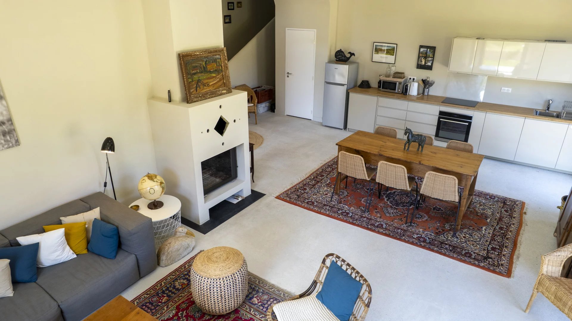 Intérieur d'une villa contemporaine à Roquefort-la-Bédoule, avec salon, salle à manger et cuisine ouverte.