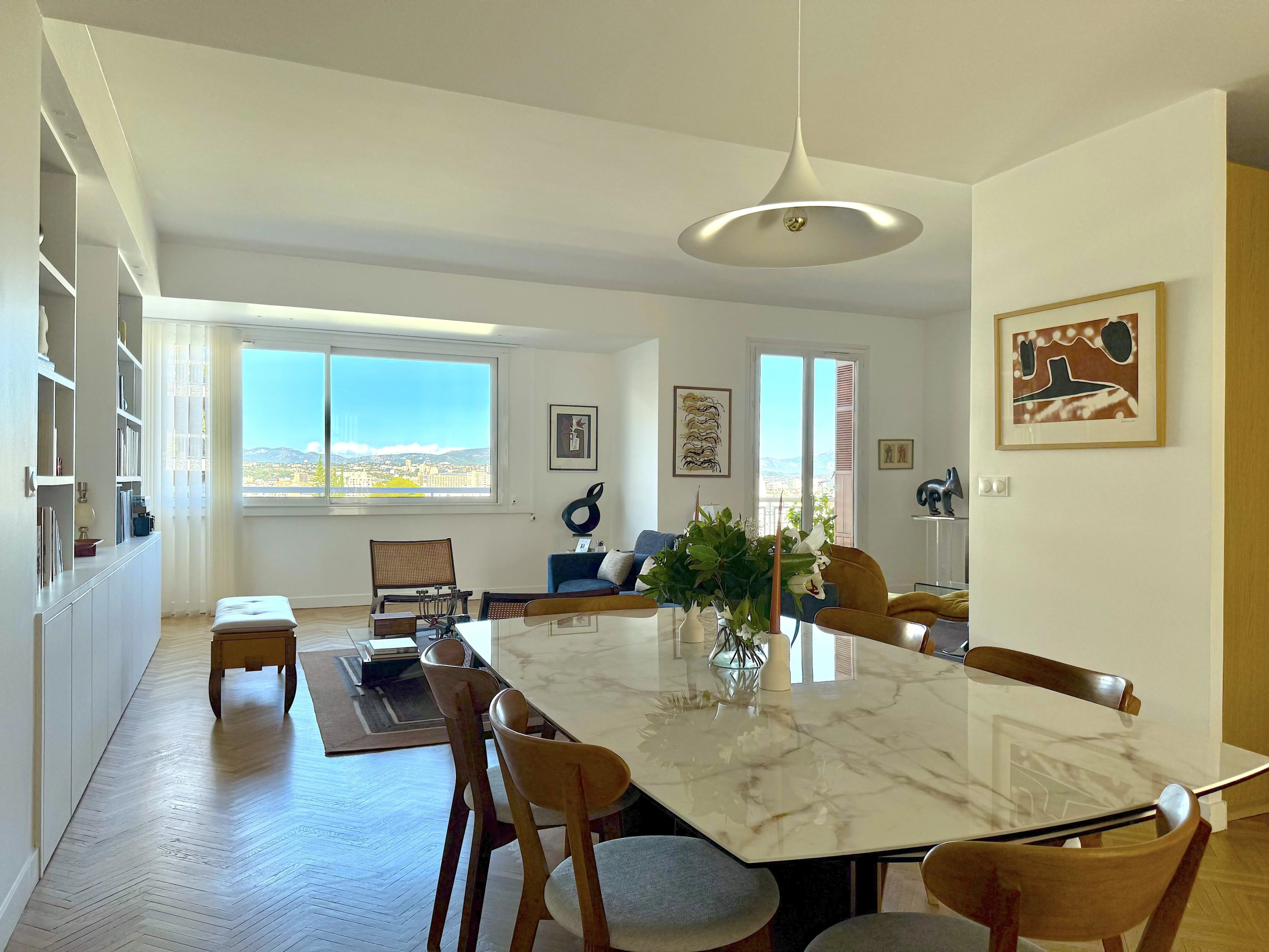 Appartement rénové au Carré d’Or, Marseille Intérieur d'un appartement rénové avec une table en marbre et une vue sur la ville.