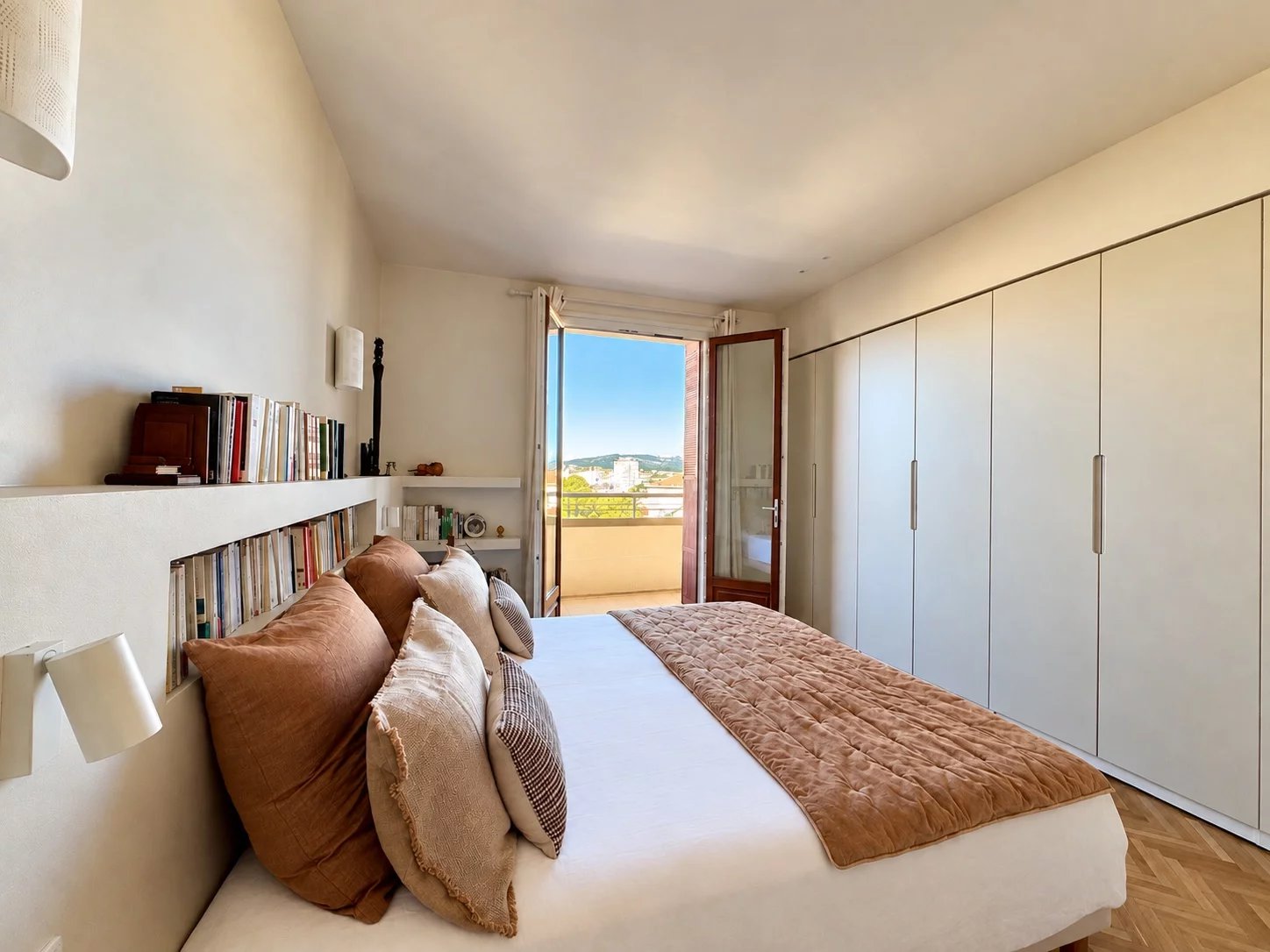 Chambre d’un appartement rénové à Marseille 8e Chambre d'un appartement rénové avec lit, bibliothèque et accès à un balcon à Marseille 8e.