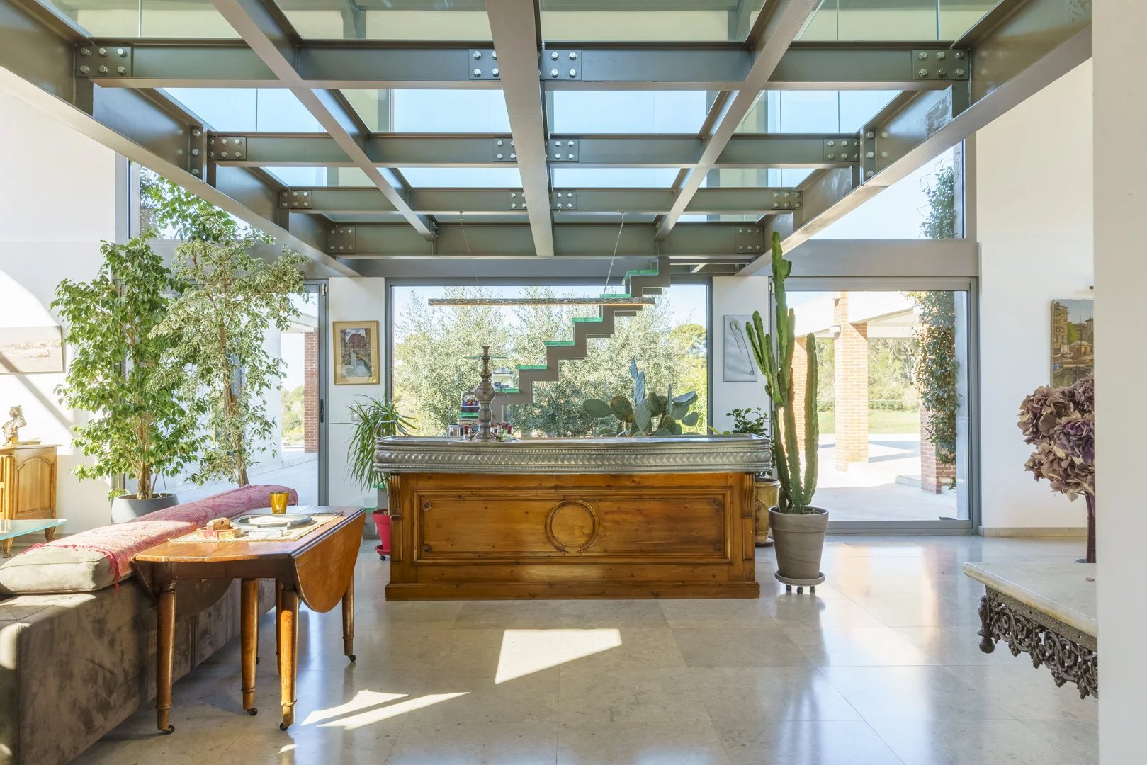 Interior of a modern architect-designed villa with a wooden bar and plants, Bouc-Bel-Air.