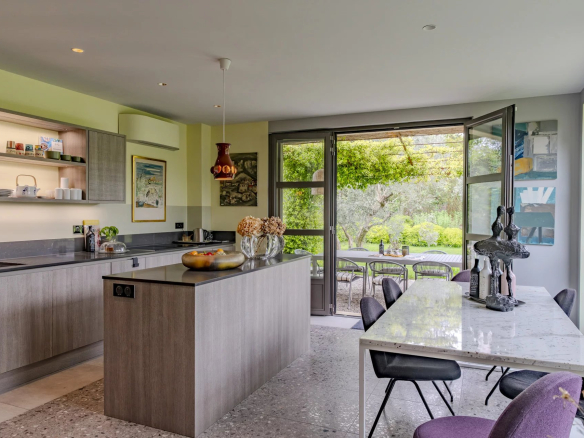 Intérieur moderne d'un mas à Eygalières avec cuisine ouverte et vue sur le jardin.