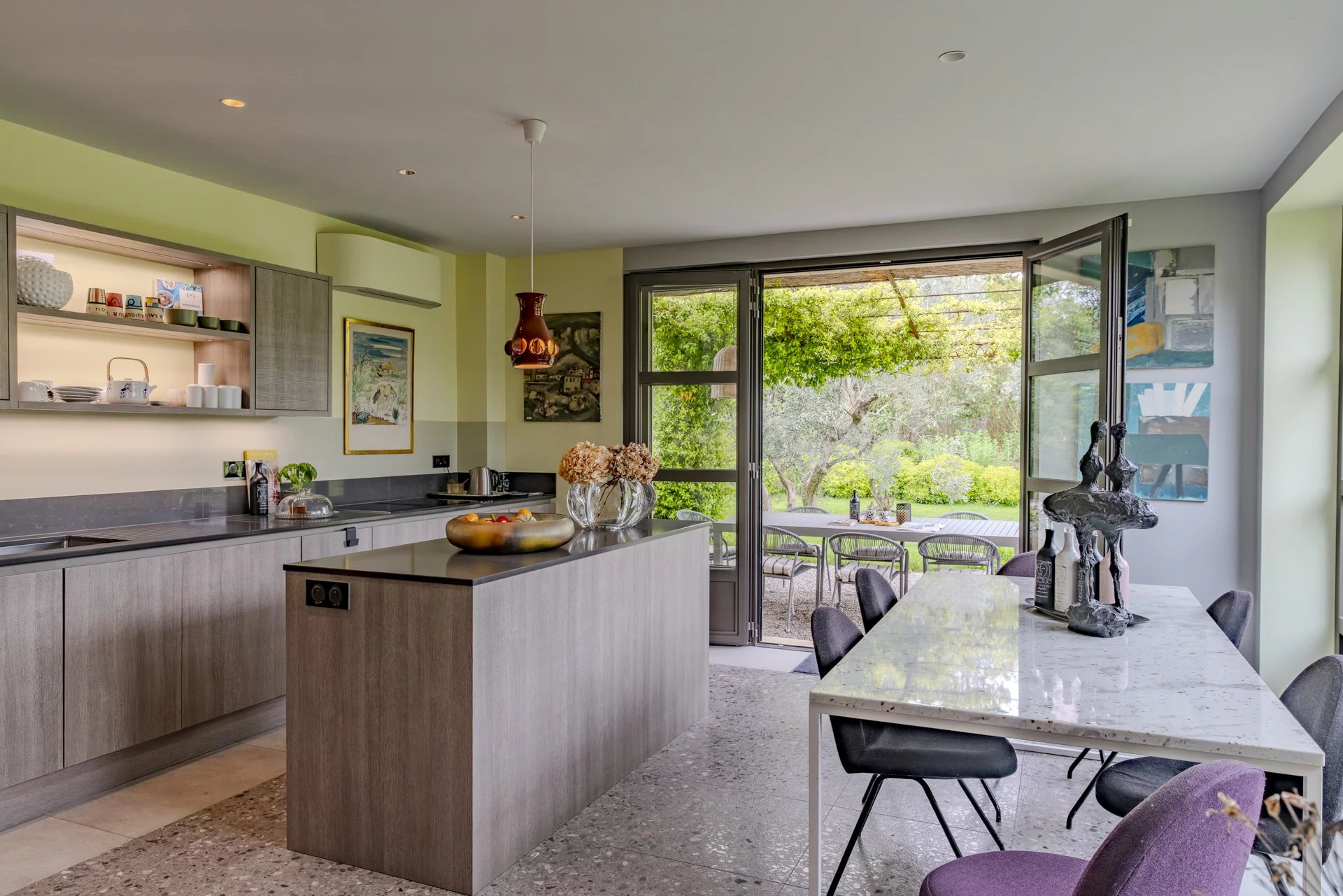 Intérieur d’un mas à Eygalières Intérieur moderne d'un mas à Eygalières avec cuisine ouverte et vue sur le jardin.