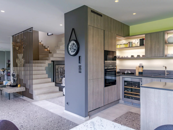 Intérieur moderne d'un mas à Eygalières avec cuisine ouverte et escalier en pierre.