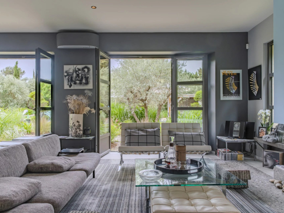 Intérieur moderne d'un mas à Eygalières avec salon lumineux et vue sur le jardin.