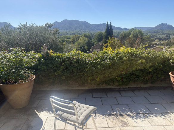 Terrasse avec vue sur les Alpilles, Eygalières, entourée de végétation méditerranéenne.