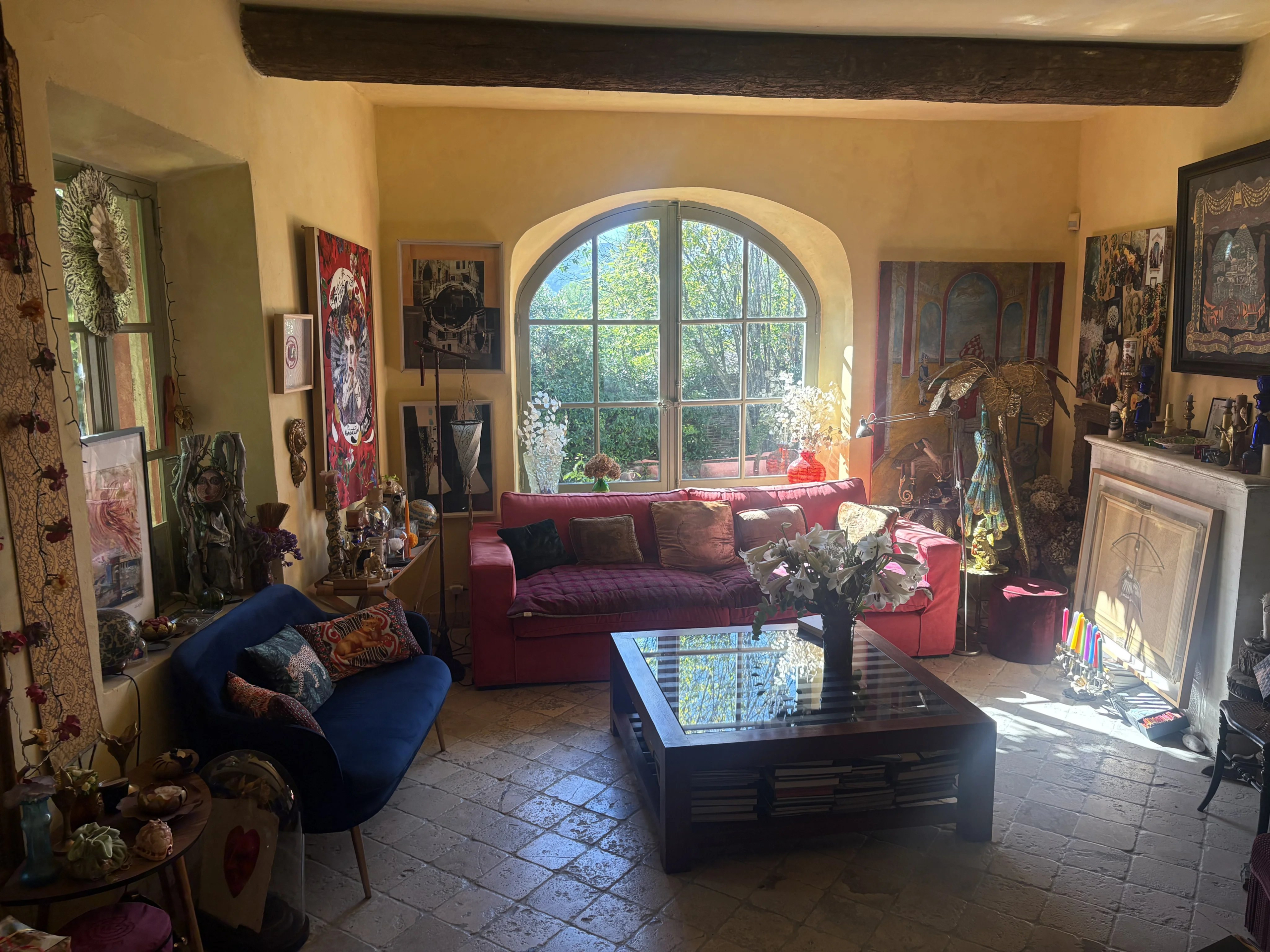 Salon d’une maison de village à Eygalières Intérieur d'une maison de village en pierre à Eygalières, avec un salon lumineux et une vue sur la végétation.