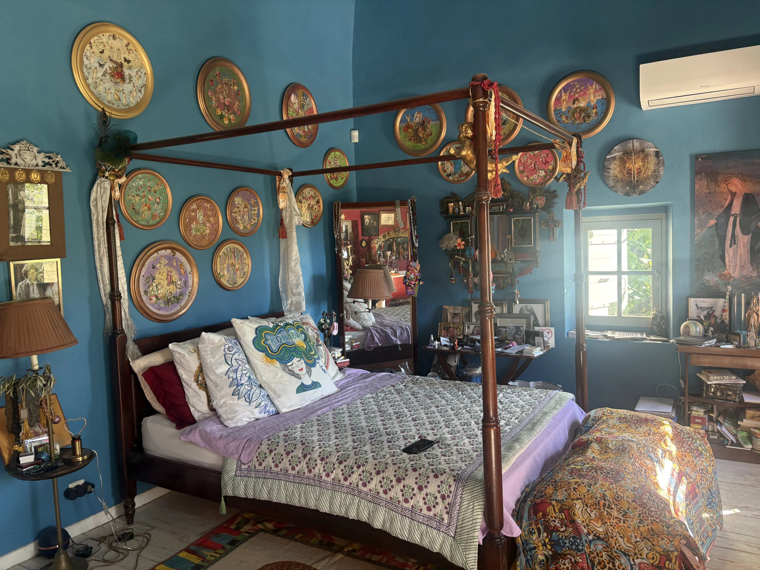 Chambre colorée d’une maison en pierre Chambre d'une maison de village avec des murs bleus et des décorations murales colorées.