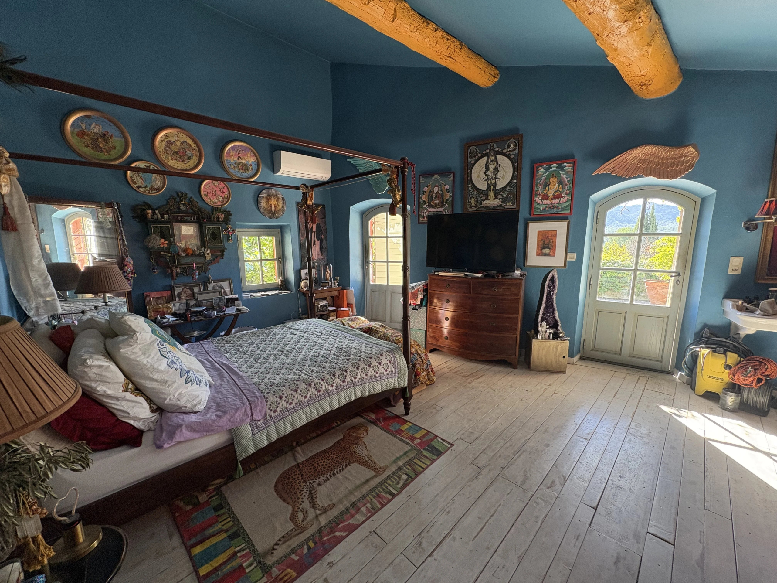 Chambre de maison en pierre à Eygalières Chambre d'une maison de village en pierre à Eygalières avec décor coloré et vue sur les Alpilles.