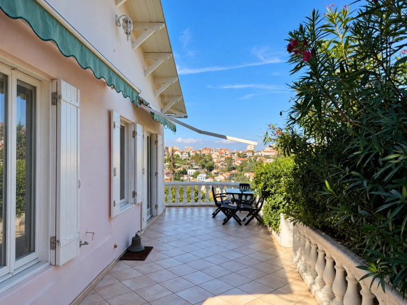 Terrasse d'une maison avec vue sur Marseille et la mer, entourée de verdure.