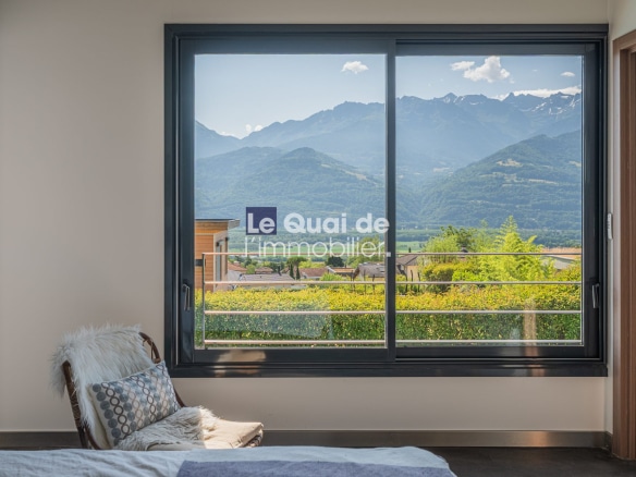 Vue depuis une fenêtre d'une villa avec des montagnes en arrière-plan à Bernin.