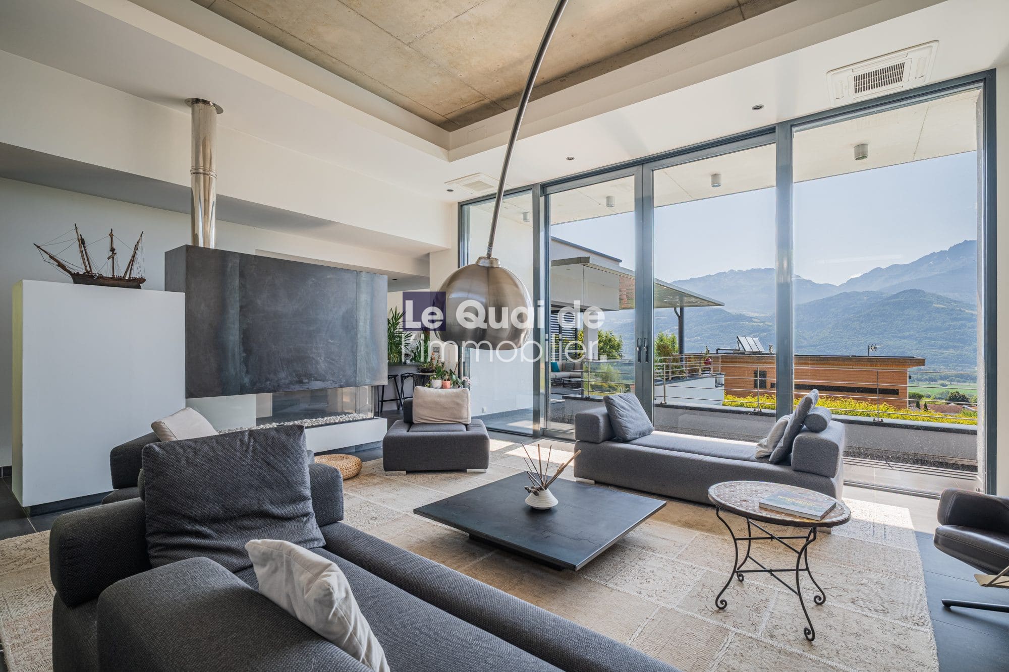 Intérieur d'une villa moderne avec vue sur les montagnes, salon spacieux et lumineux.
