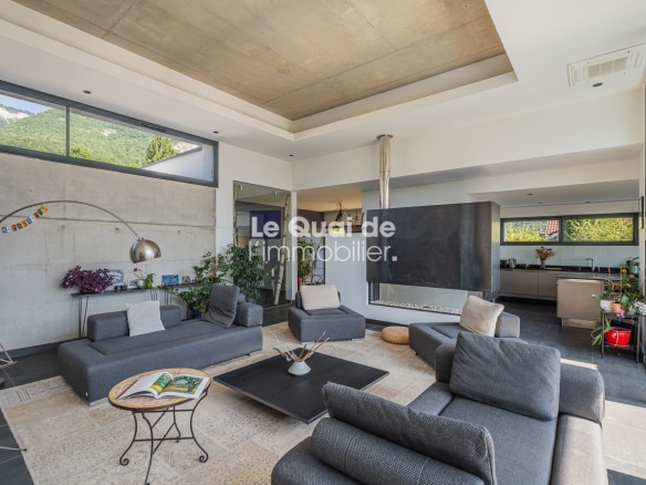Intérieur d'une villa d'architecte moderne avec salon spacieux et cuisine ouverte à Bernin.