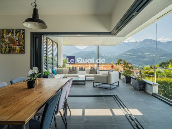 Intérieur d'une villa moderne avec vue sur les montagnes, espace lumineux et mobilier contemporain.
