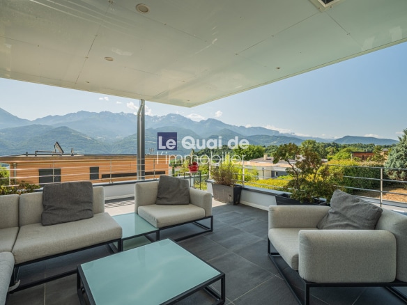 Terrasse moderne avec vue sur les montagnes et la villa d'architecte à Bernin.