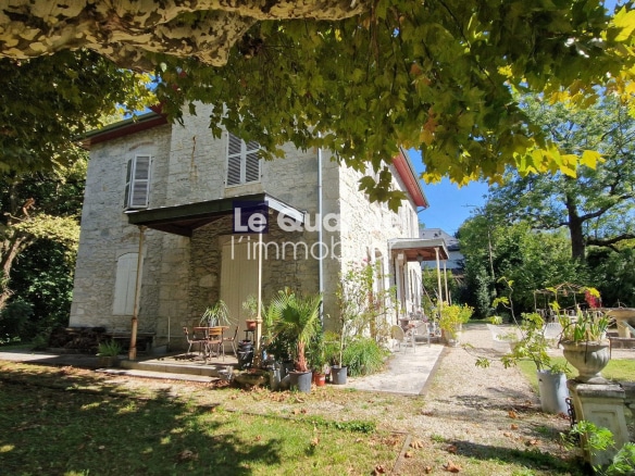 Maison de maître en pierre avec jardin verdoyant à Chambéry, vue sur parc.