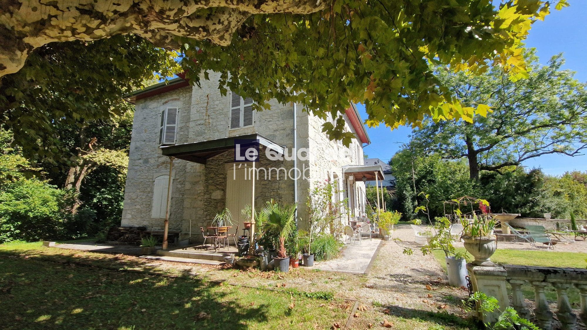 Maison de maître en pierre avec jardin verdoyant à Chambéry, vue sur parc.