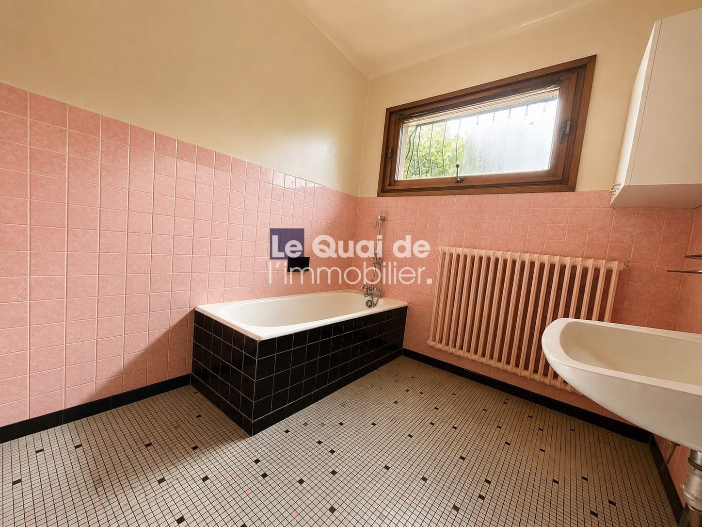 Salle de bain avec baignoire et lavabo dans une maison à vendre à Drumettaz-Clarafond.