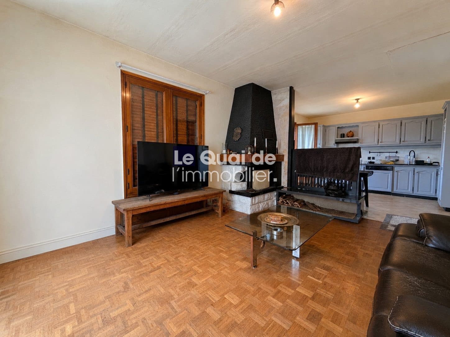 Intérieur d'une maison à vendre à Drumettaz-Clarafond, avec un salon et une cheminée.