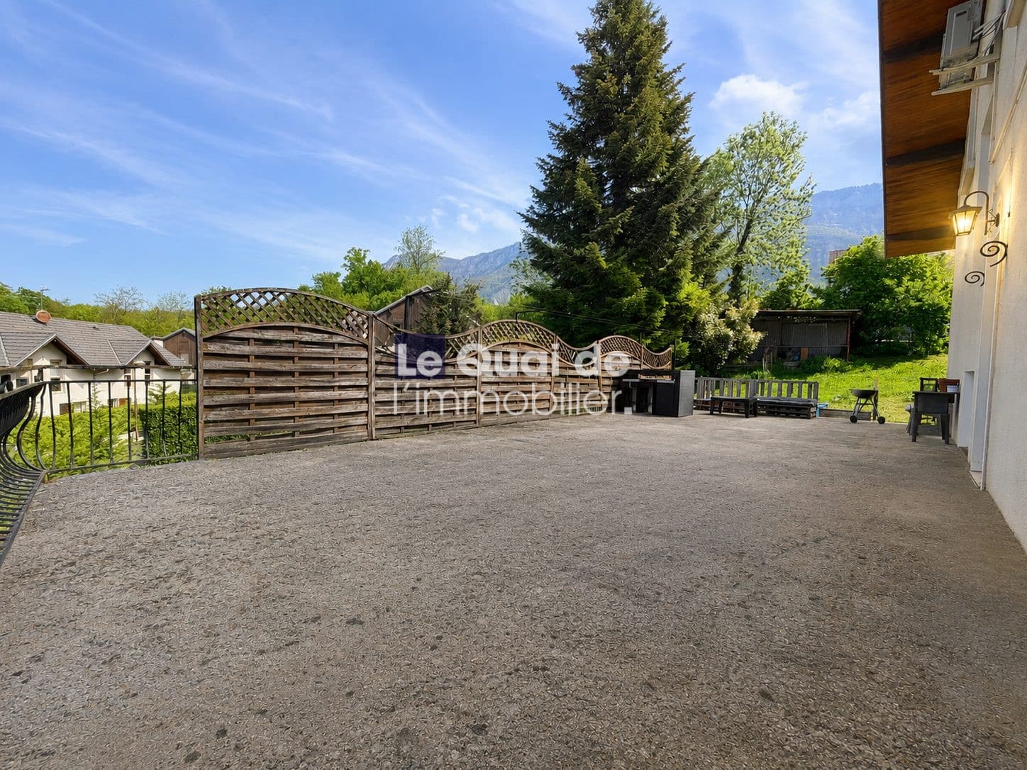 Terrasse d'une maison à vendre à Drumettaz-Clarafond avec vue sur la verdure.