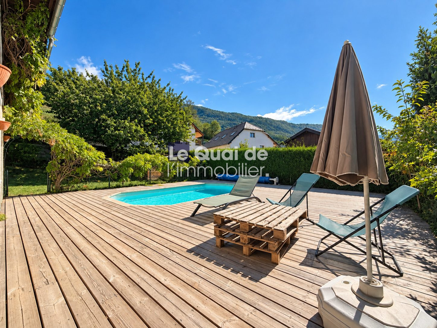 Wooden terrace with swimming pool and sun loungers in Nâves-Parmelan