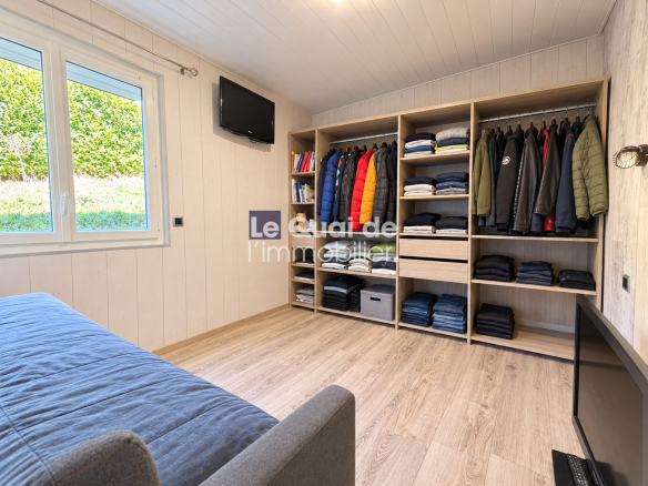 Room with storage and television in a house in Nâves-Parmelan.
