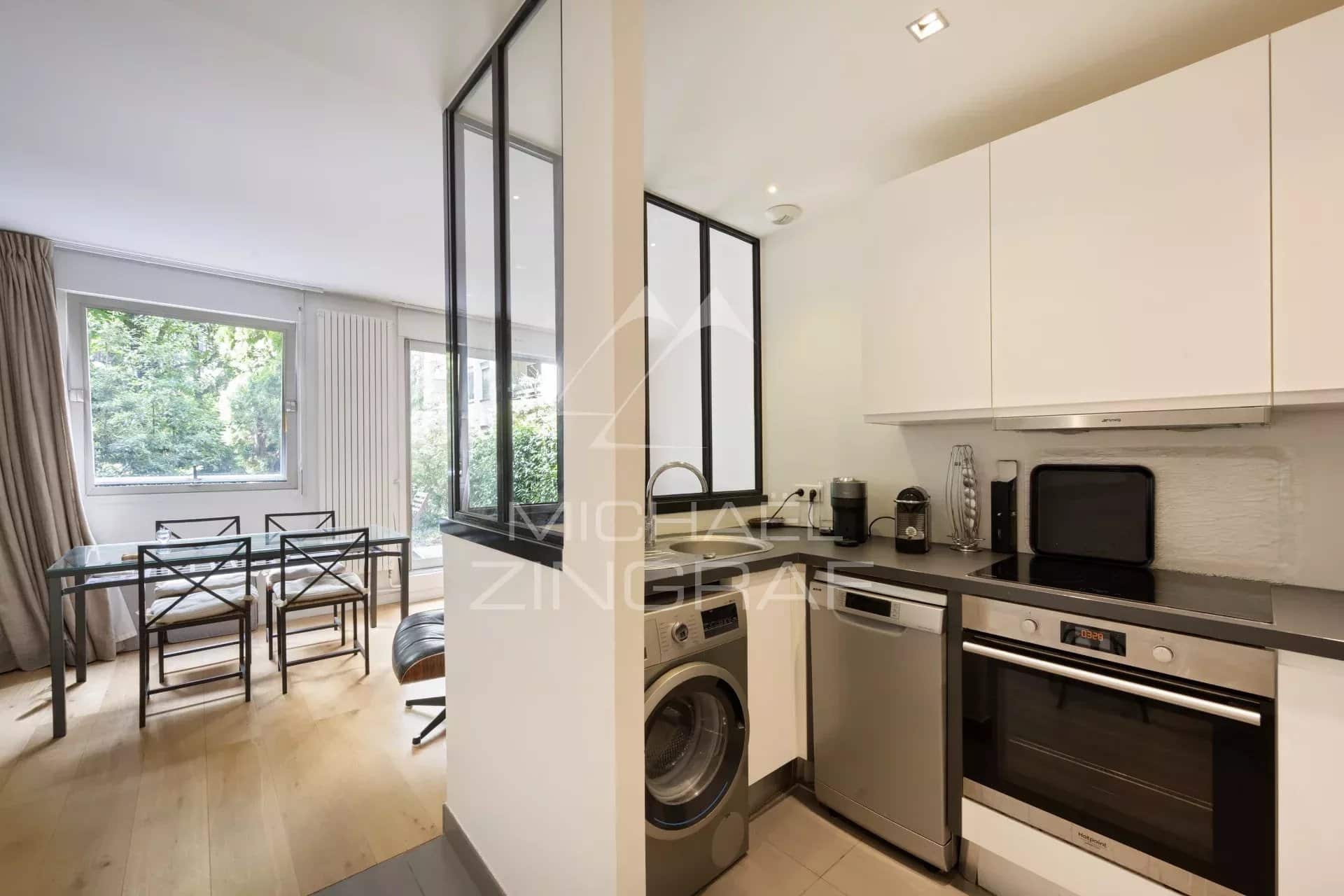 Cuisine équipée avec espace salle à manger, appartement en rez-de-jardin à Neuilly-sur-Seine.