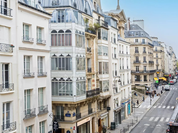 Vue de la rue Saint Honoré à Paris, montrant des bâtiments et commerces