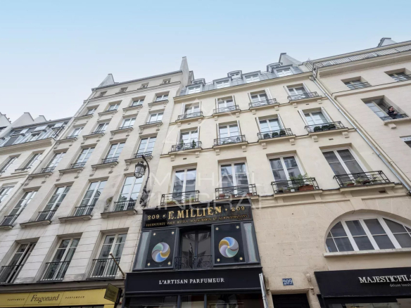 Façade d'un immeuble sur la rue Saint Honoré à Paris, avec boutiques au rez-de-chaussée.