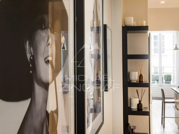 Intérieur d'un appartement moderne avec des œuvres d'art au mur, éclairage naturel.