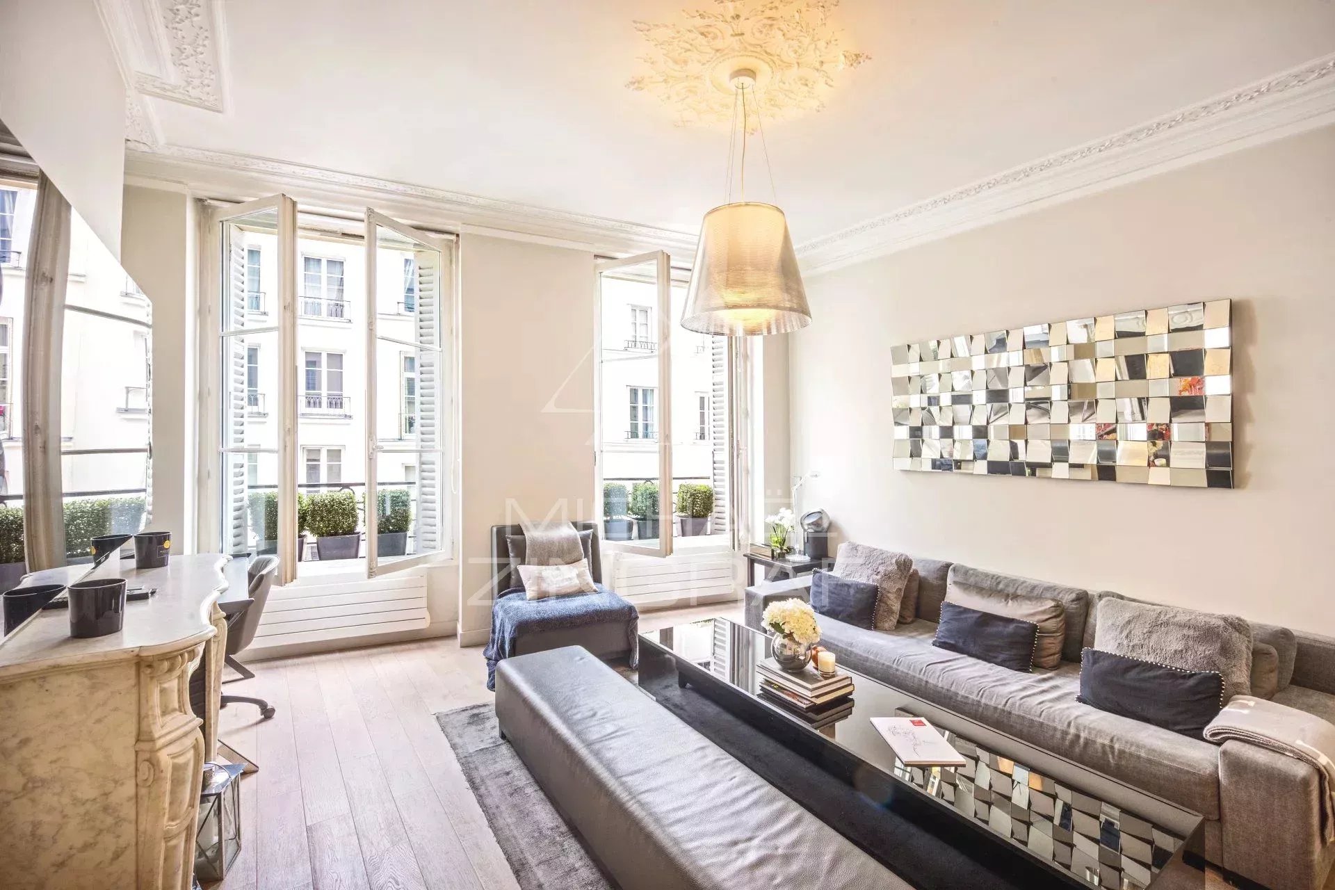 Salon d'un appartement climatisé à Paris, avec fenêtres ouvertes et décoration moderne.