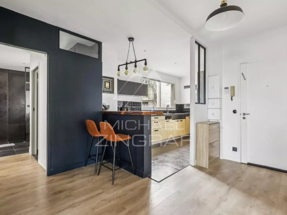 Intérieur d'un appartement à Paris 16ème avec cuisine ouverte et coin repas.