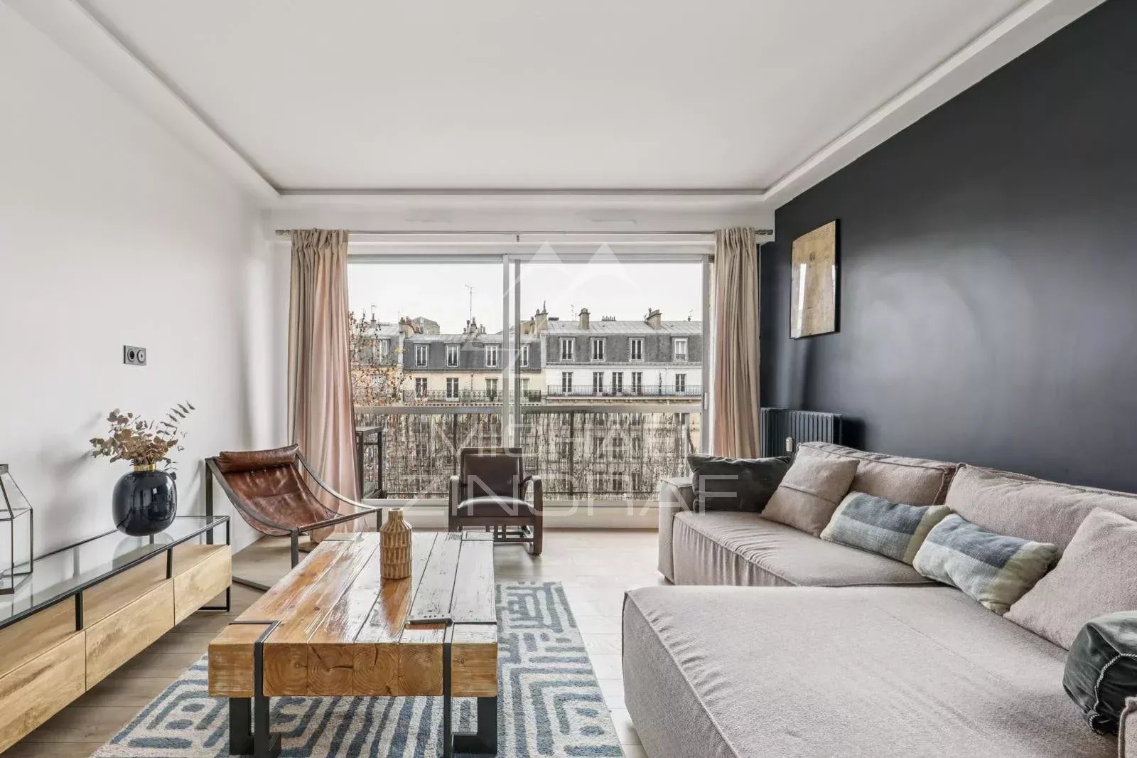Salon d’appartement à vendre à Paris 16ème Salon lumineux d'un appartement à Paris 16ème avec balcon et vue dégagée.
