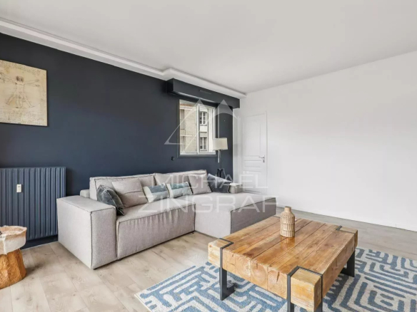 Salon lumineux d'un appartement à vendre à Paris 16ème, avec canapé et table basse en bois.